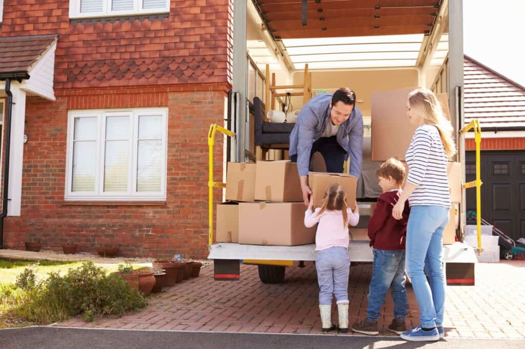 A family unloading boxes from the truck