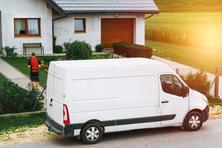 A white moving van in front of a house