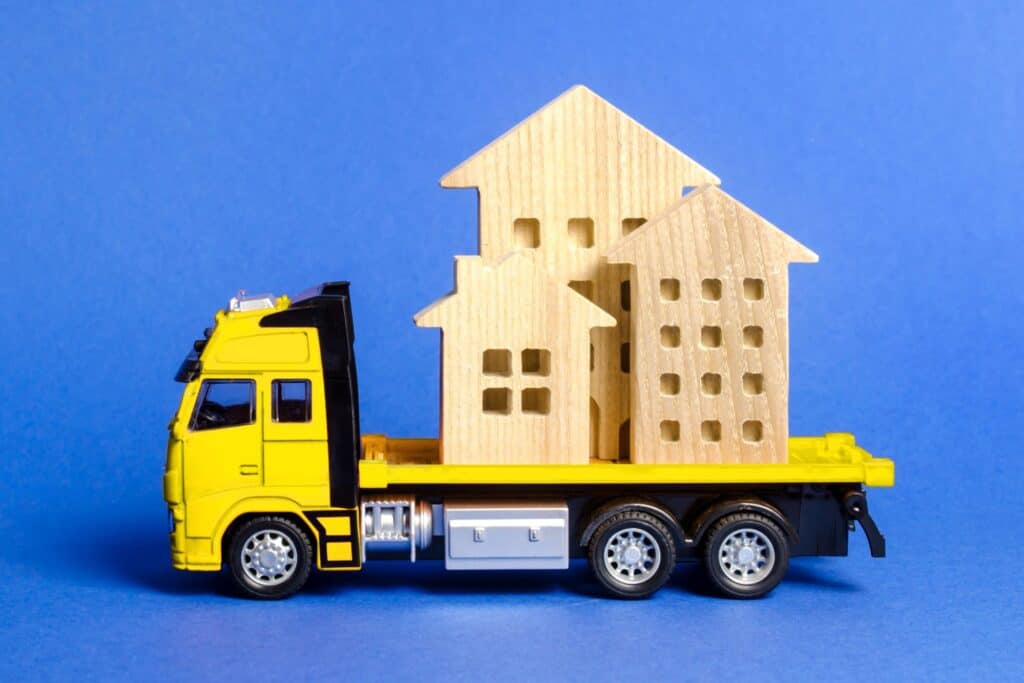 a yellow cargo toy truck with figures of houses