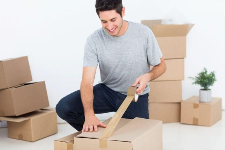 A man wrapping a box with sticky tape