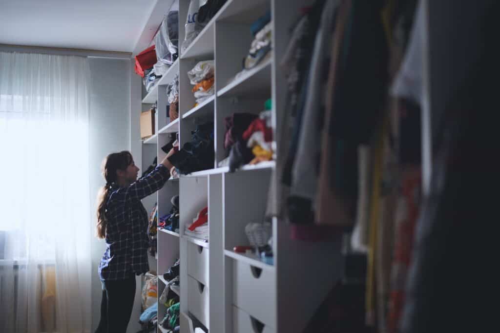 A mother looking for clothes in a messy closet