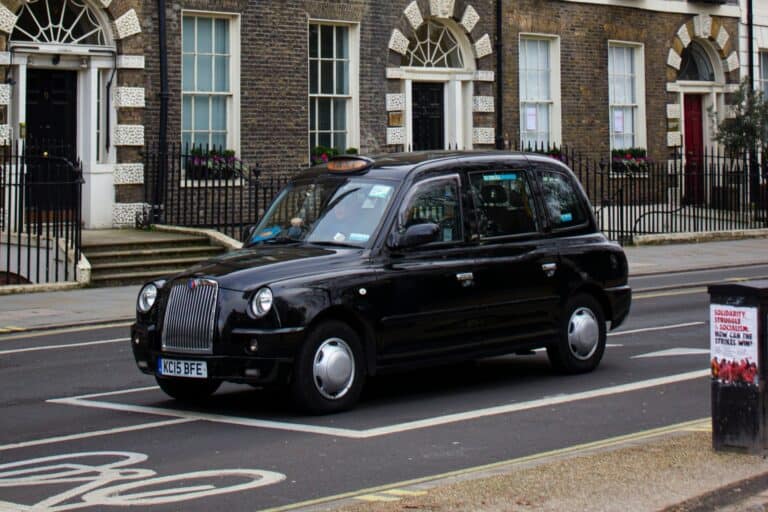 A black taxi on the street in the concept of Hackney's public transport.