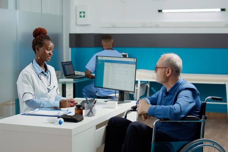 A patient in wheelchair consulting with a general practitioner in a clinic in the concept of 'top services and amenities in Hackney'.