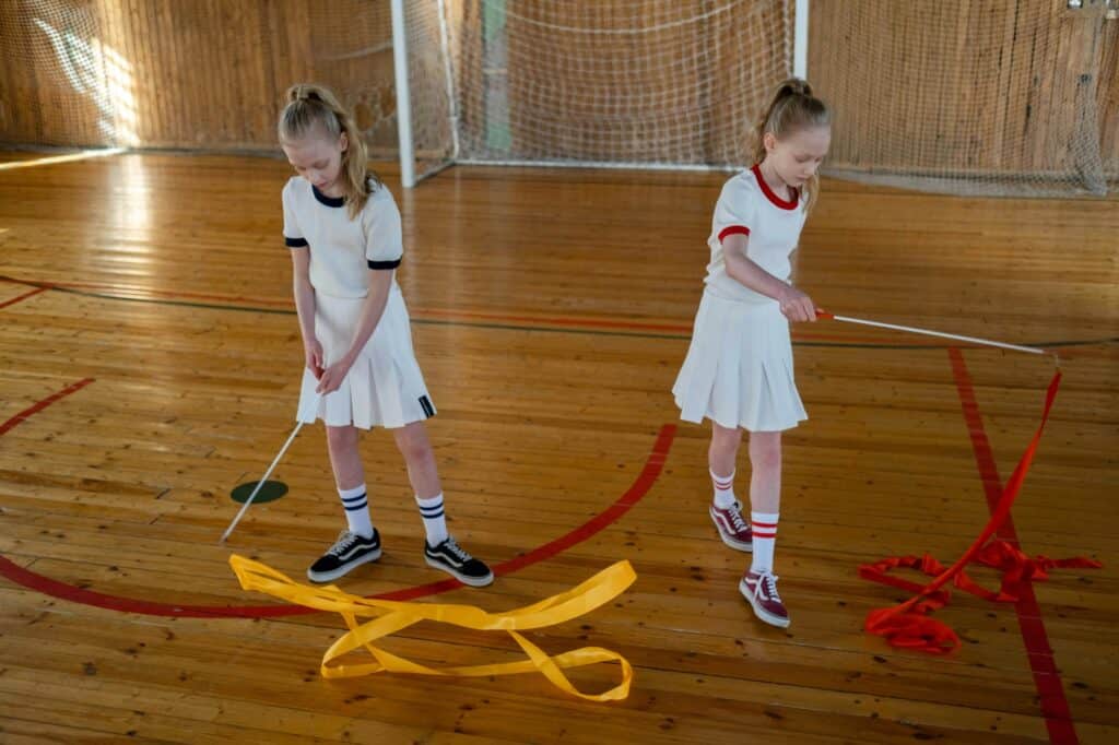 Two female students in a gymnastics class in the concept of 'top schools in Hackney'.